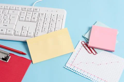 Light blue desk with different sizes of empty paper notes, computer keyboard and 스톡 사진