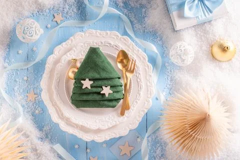 Light blue holiday table setting with snowy trimmings. Stock Photos