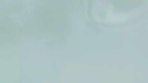 Light blue liquid creating ripples and waves in slow motion. Cosmetic cream.. Stock Footage 335139208