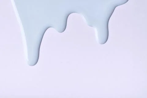 Light blue liquid drops of paint color flow down on gray background. Abstract Stock Photos