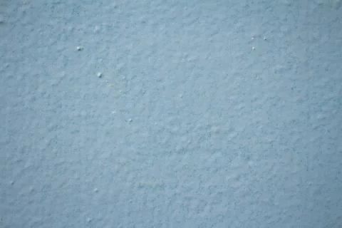 Light blue painted wall texture with bumpy surface and uneven finish backgrou 库存照片