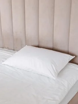 Light blue pillow on bed side angle Stock Photos