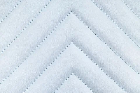 Light blue quilted leather texture with chevron stitching pattern, luxury uph Foto stock