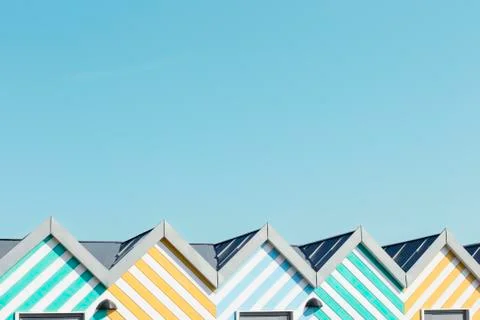 Light blue sky background and top roof of color striped beach hut and copy space Stock Photos