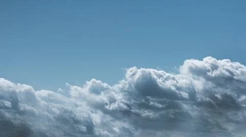 Light blue sky with cumulus clouds of gray color Stock Photos