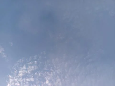 Light Blue Sky with Fleecy Clouds Stock Photos