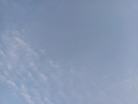 Light Blue Sky with Patchy Clouds Stock Photos