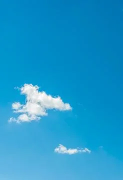 The light blue spring sky with two small clouds Stock Photos