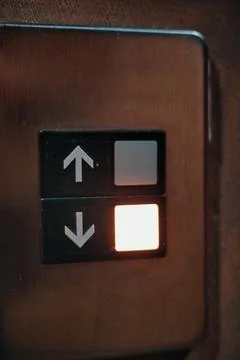 Light Up Botton Going Down Arrow On The Elevator In A Building Stock Photos