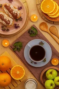Light breakfast of black coffee, fruit and cakes on a wooden table Stock Photos