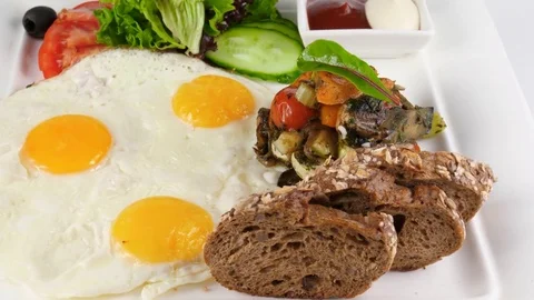 Light Breakfast with fried eggs, vegetables and whole wheat bread Stock Footage 78527828