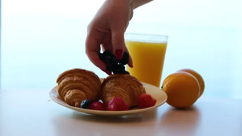 Light breakfast with intricate silver egg holder, golden spoon, glass of orange Stock Footage 317725391