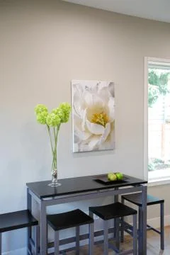 Light Breakfast nook showcases black table with stools and a nice large frame Stock Photos