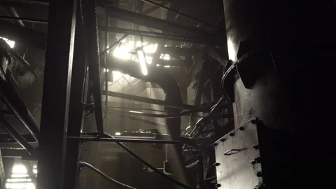 Light breaks through abandoned factory decayed ceiling illuminating pipes dust Stock Footage 264700171