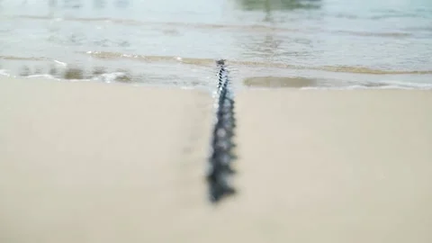 Light breeze on the sea. Waves run on a boat chain lying on the sand Video stock 147209292
