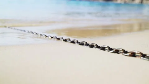 Light breeze on the sea. Waves run on a boat chain lying on the sand Stock Footage 147209640