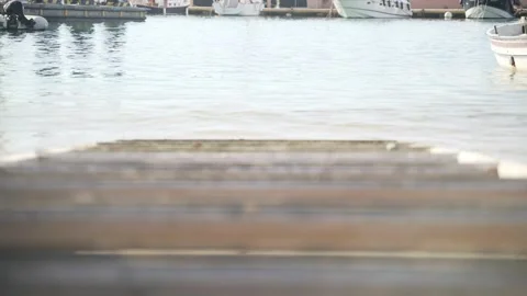 Light breeze on the sea. Waves run into the old wooden pier. Transparent sea Video stock 147209757