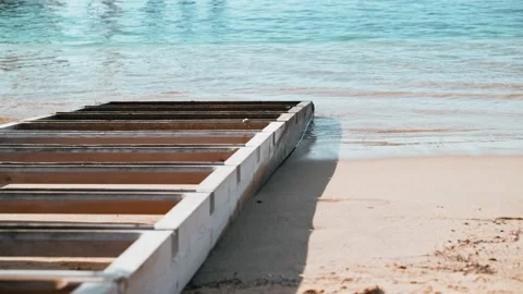 Light breeze on the sea. Waves run into the old wooden pier. Transparent sea Video stock 147210009