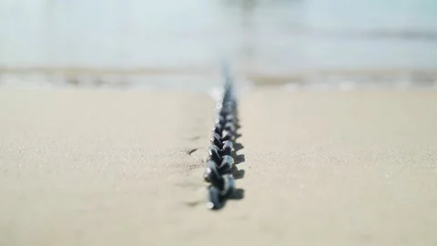Light breeze on the sea. Waves run on a boat chain lying on the sand Stock Footage 147328902