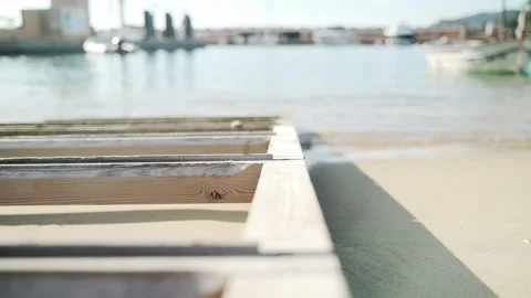 Light breeze on the sea. Waves run into the old wooden pier. Transparent sea Stock Footage 147328982