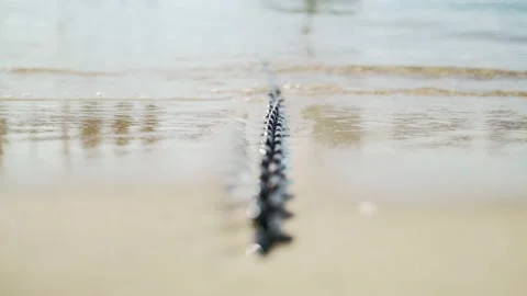 Light breeze on the sea. Waves run on a boat chain lying on the sand Stock Footage 147329049