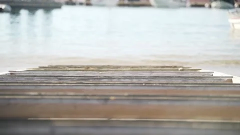 Light breeze on the sea. Waves run into the old wooden pier. Transparent sea Stock Footage 147329257