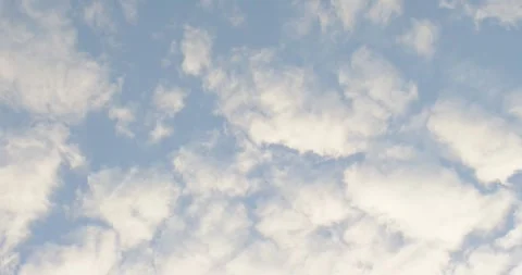 Light breeze is stirring cloud field across pale blue sky, drifting and Stock Footage 345088792