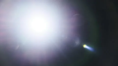 The Light of a Bright Flashlight Directed at the Camera Moves From Side to Side Stock Footage 231863205