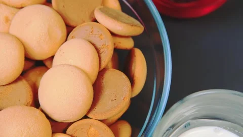 Light brown biscuits resting in glass bowls on kitchen table Stockbeeldmateriaal 342839388