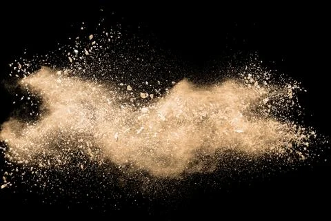 Light brown dust explosion cloud.Brown particles splatter on black background Stock Photos