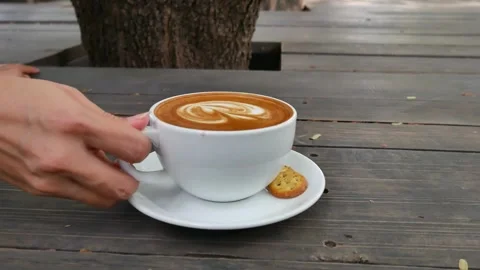A light brown fresh mocha with a pretty latte art outdoors on a cafe in Paris. Stock-Footage 334648816