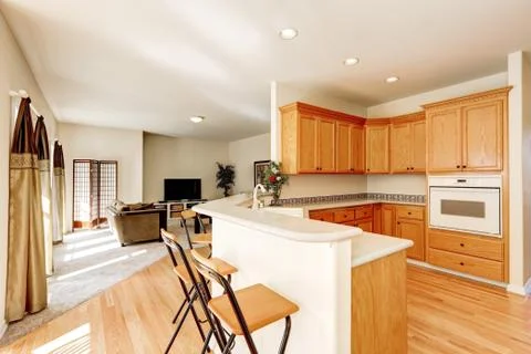 Light brown kitchen cabinets and bar counter with stools. Northwest, USA Stock Photos