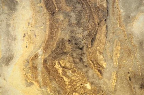 Light brown marble with a wavy pattern and splashes of white. Stock Photos