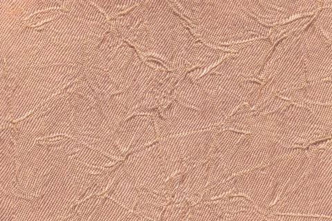 Light brown wavy background from a textile material. Fabric with fold texture Stock Photos
