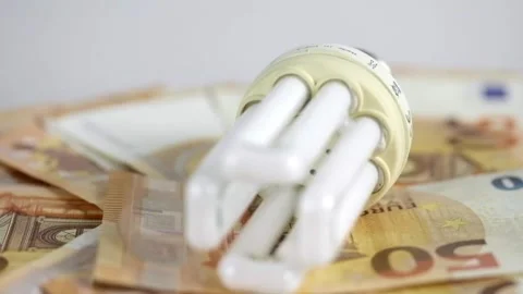 Light bulb with 50 euro note bills , Increase in electricity tariffs Stock Footage 273873092