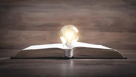 Light bulb and book. Knowledge and wisdom Stock Photos