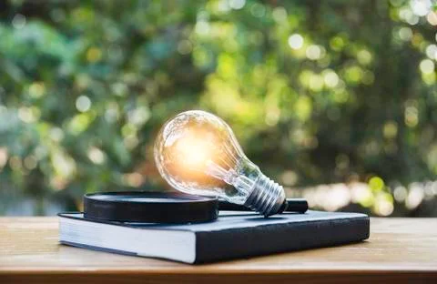 Light bulb and a book on table and copy space for insert text. Stock Photos