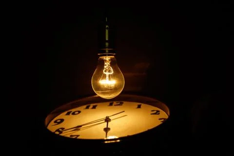 Light bulb and clock Stock Photos