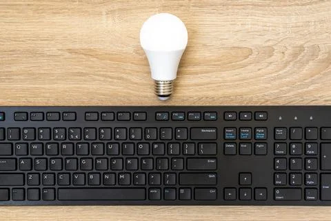 A light bulb and computer keyboard Stock Photos