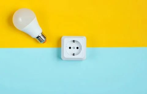 Light bulb and electrical outlet on colorful background Stock Photos