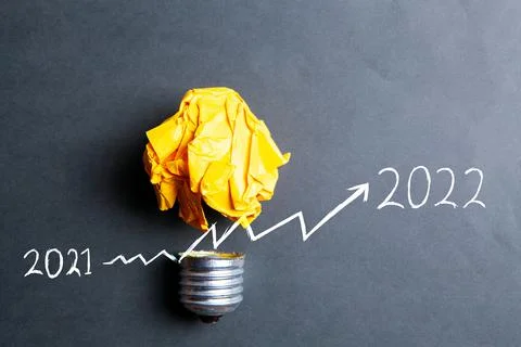 Light bulb and growing graph from 2021 to 2022 Stock Photos