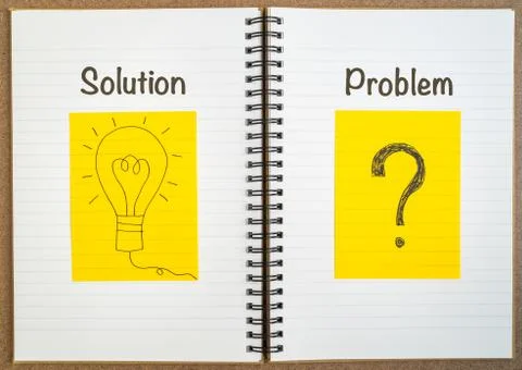 Light bulb and question mark on yellow paper on notebook Stock Photos