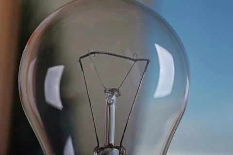 Light bulb on a background of blue sky. Stock Photos