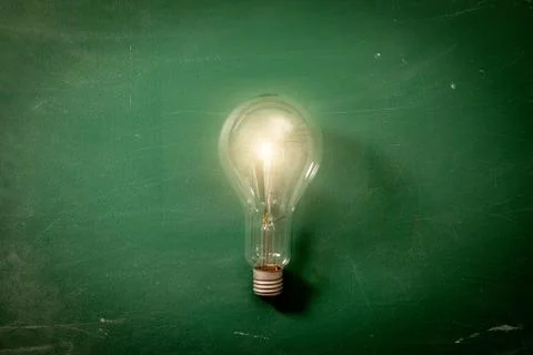 Light Bulb on a background of green chalk board Stock Photos