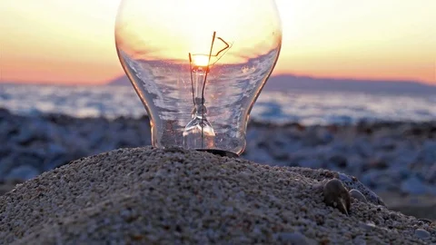 Light bulb on the beach at sunset time lapse Stock Footage 74008902