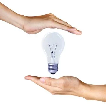 Light bulb between two hands Stock Photos