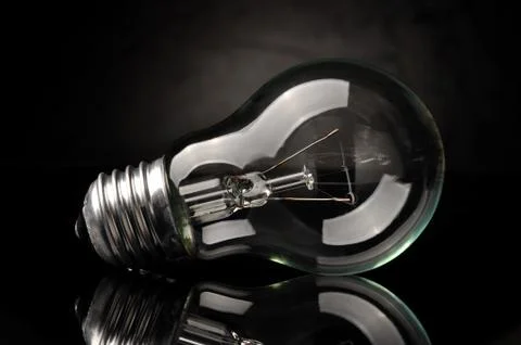 Light bulb on black background Stock Photos