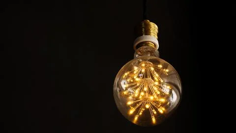 Light bulb on a black background. Stock Photos