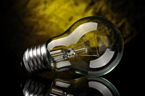 Light bulb on black yellow background Stock Photos