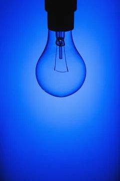 Light Bulb On Blue Background Stock Photos